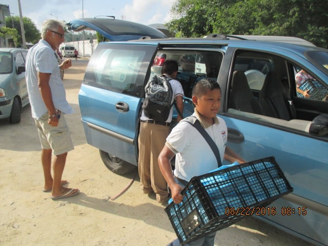 Boys helped carry boxes of KKIS bags.